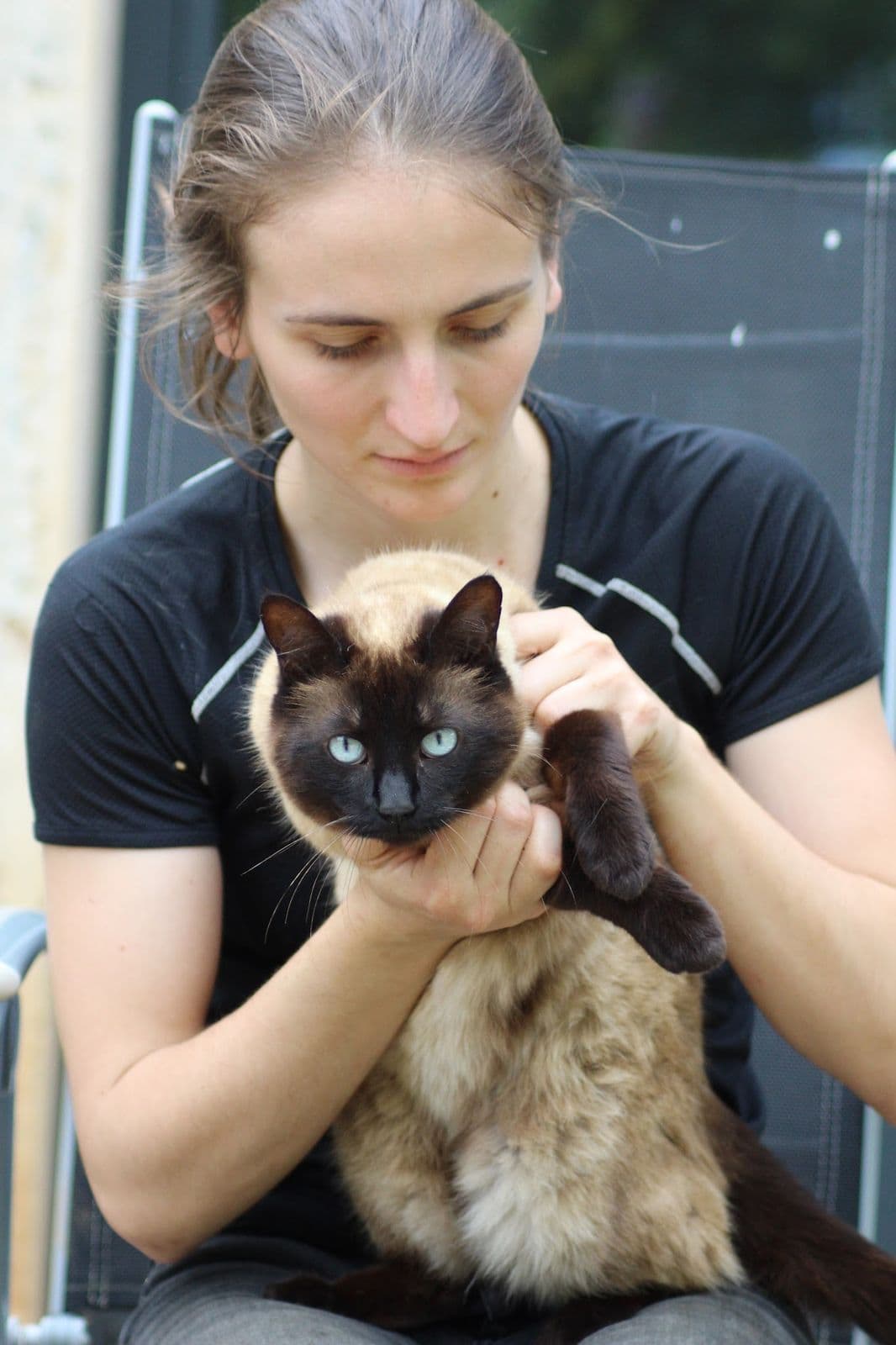 Marie Salabert tient un chat siamois dans ses bras